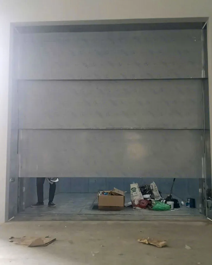 Cửa thang máy tải hàng ba tấm mở lên đang mở tại công trình